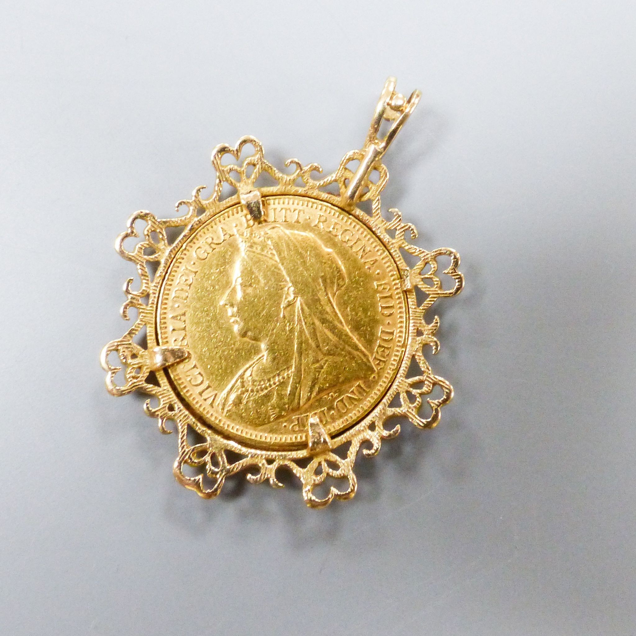 An 1894 gold sovereign in fancy yellow metal mount, overall 39mm, gross weight 12 grams.